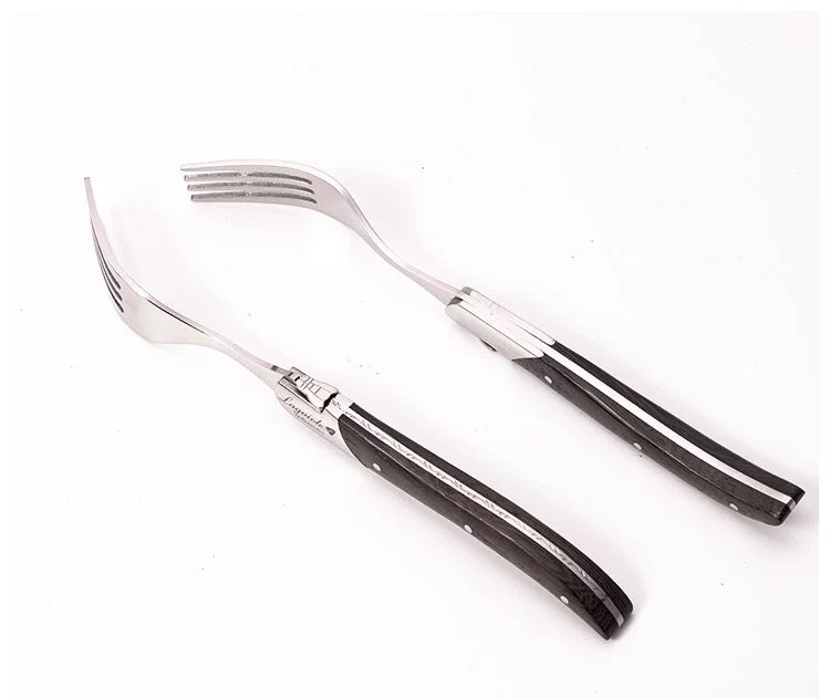 Set of silver cutlery with black handles on a white background