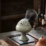 Decorative incense burner with smoke on a wooden table