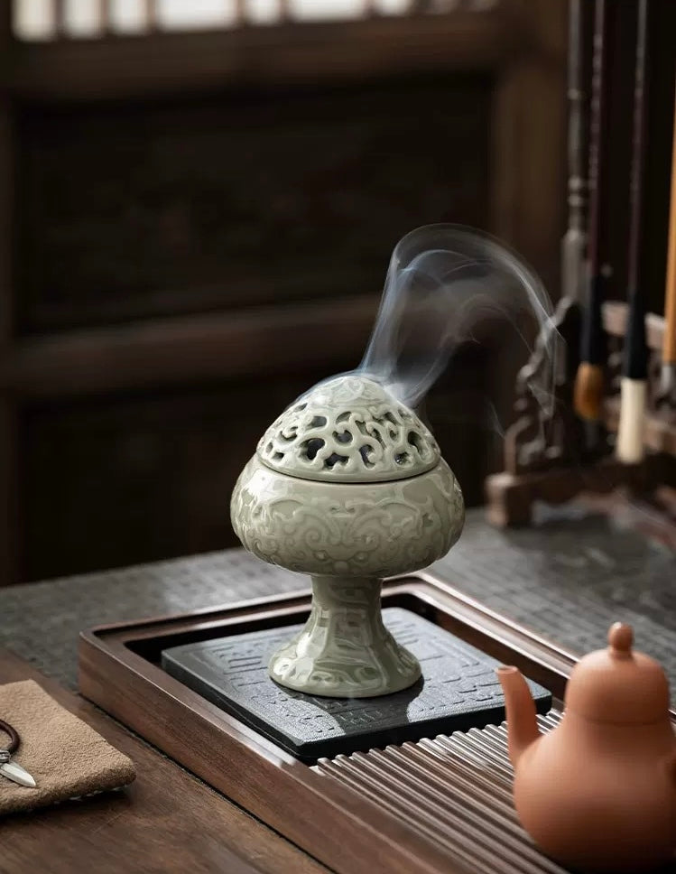 Decorative incense burner with smoke on a wooden table