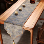 Decorative table runner with tassels on a wooden table