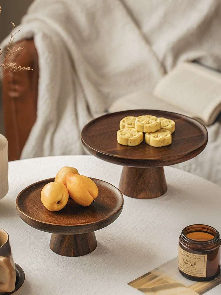 Wooden cake stands with fruits and cookies on a white surface