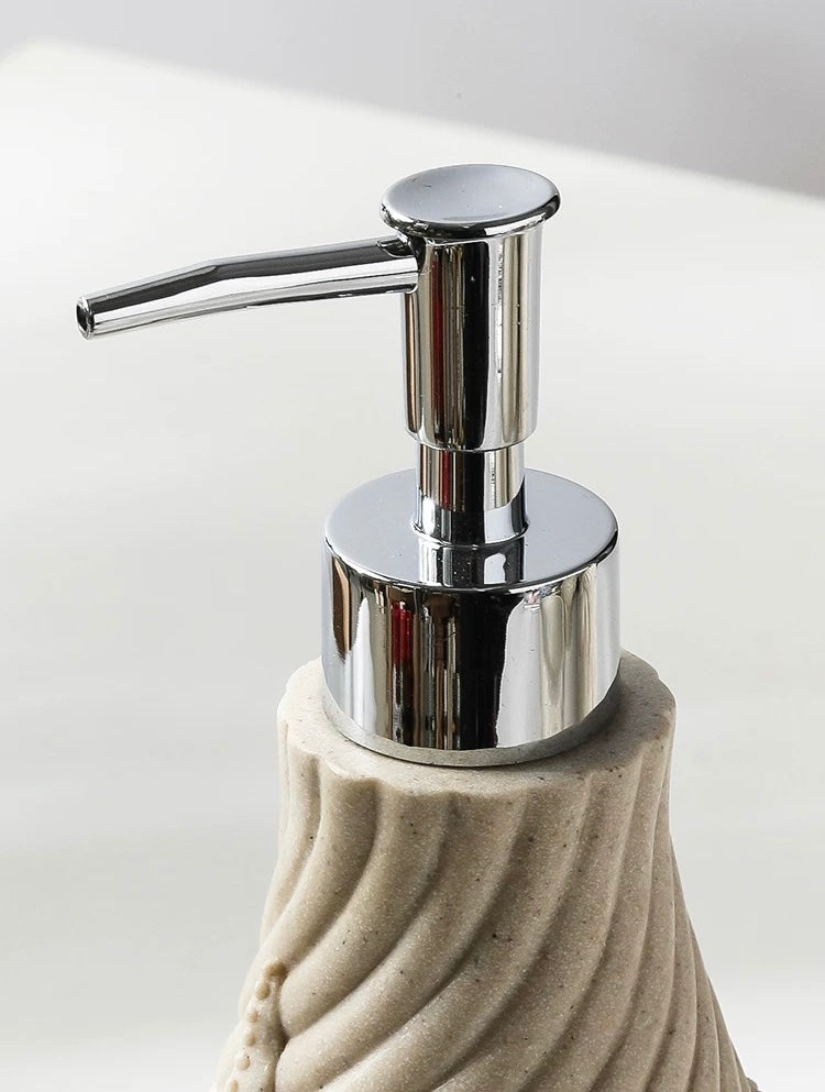 Soap dispenser with a textured beige base and chrome pump on a light background