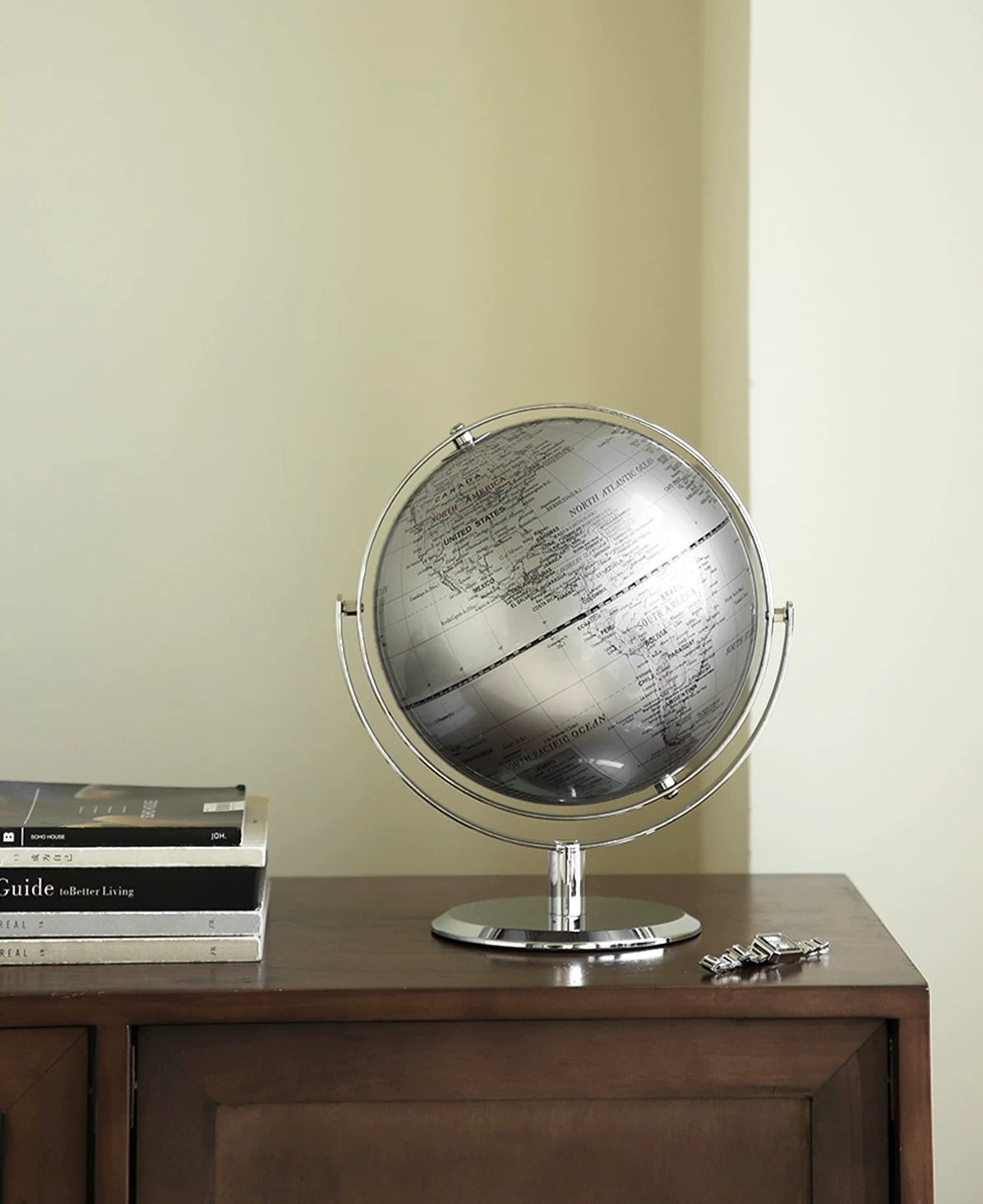 Globe on a wooden surface with books and keys in the background