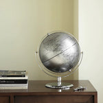 Globe on a wooden surface with books and keys in the background