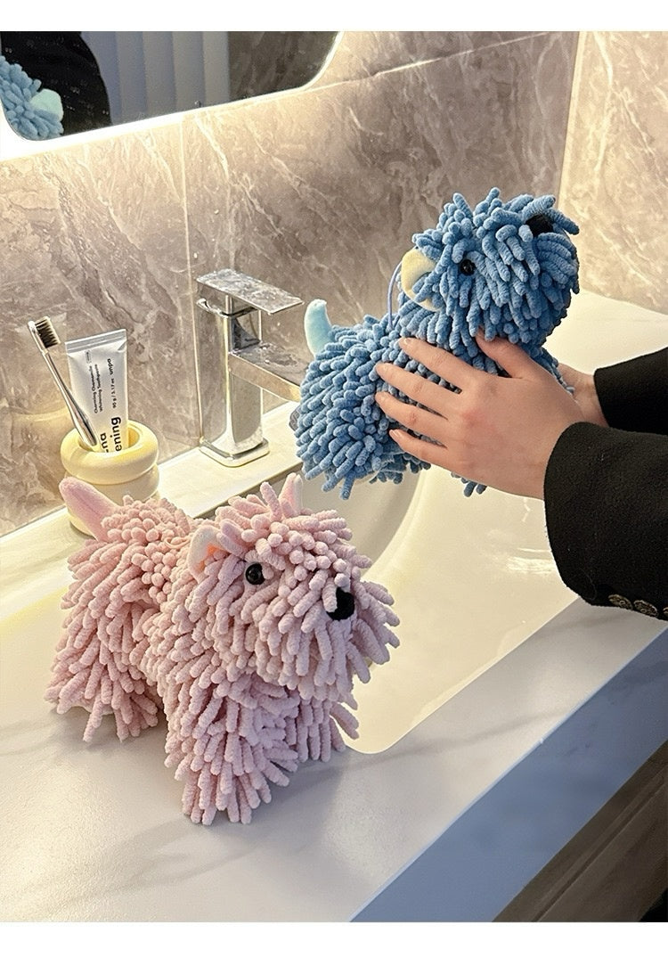 Two fluffy cleaning cloths shaped like sheep on a bathroom counter.