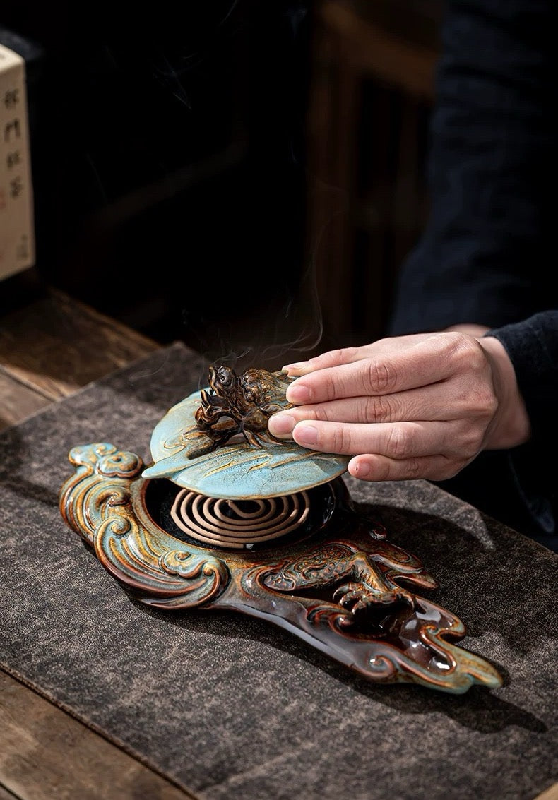 Hand interacting with an ornate metal object on a textured surface