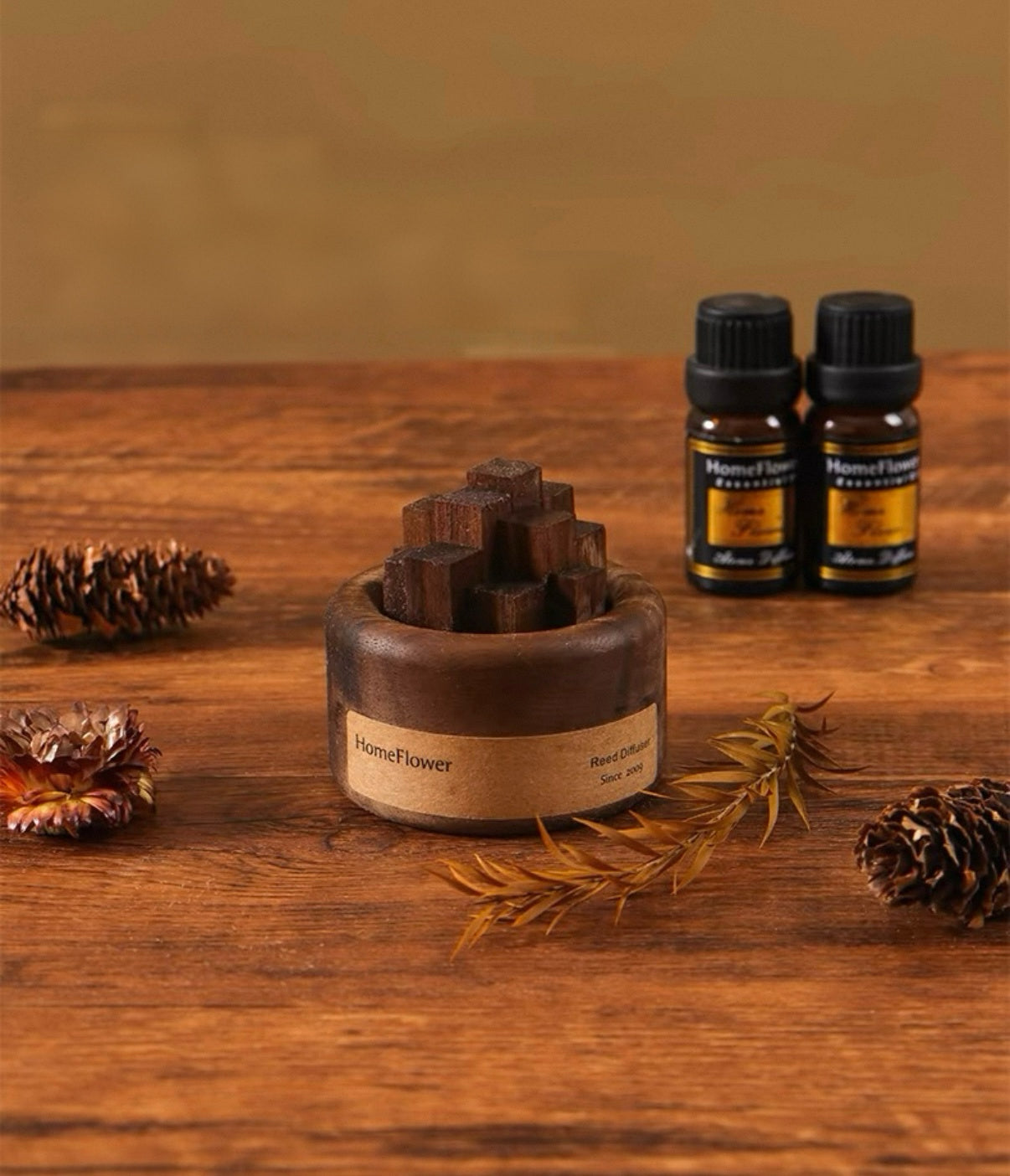 Wooden diffuser and essential oil bottles on a wooden surface with pine cones and branches.