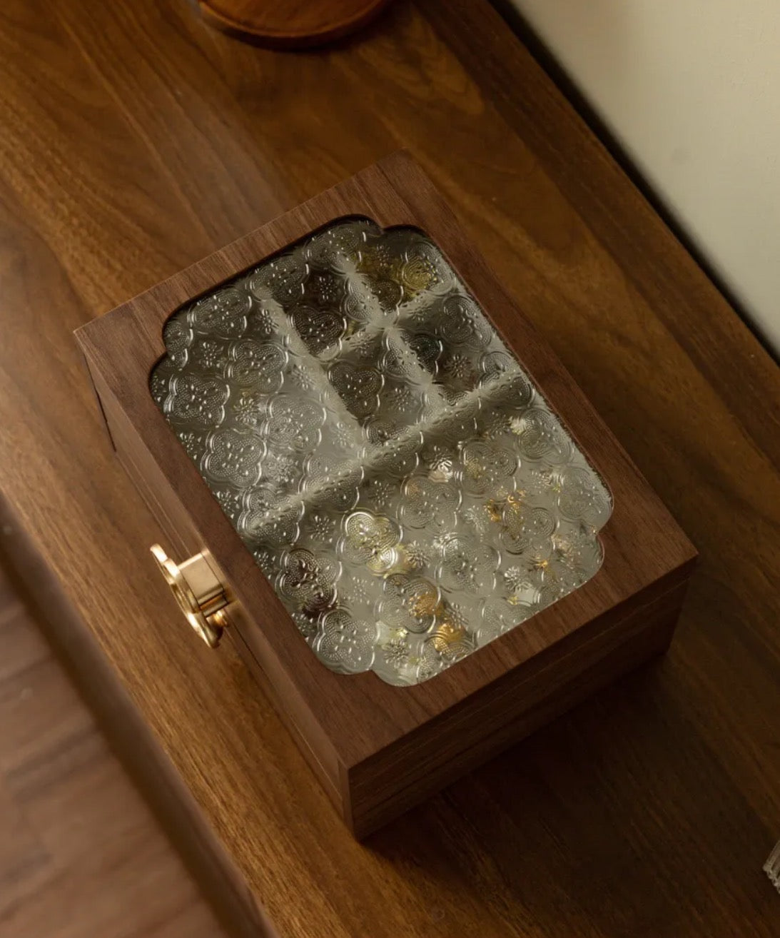 Wooden box with glass stones on a wooden surface