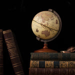 Vintage-style globe on a stack of old books with a dark background