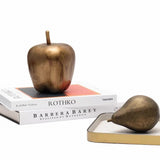 Bronze apple and pear on books with a white background
