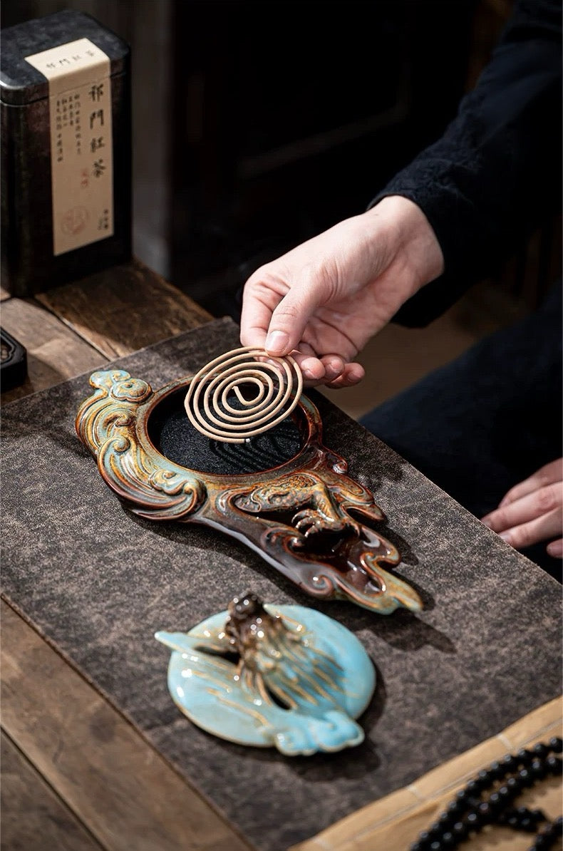 Person lighting incense on a decorative incense burner with intricate designs.