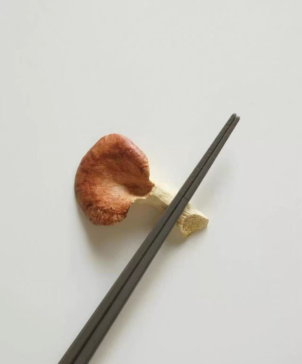 Two wooden chopsticks on a light gray background