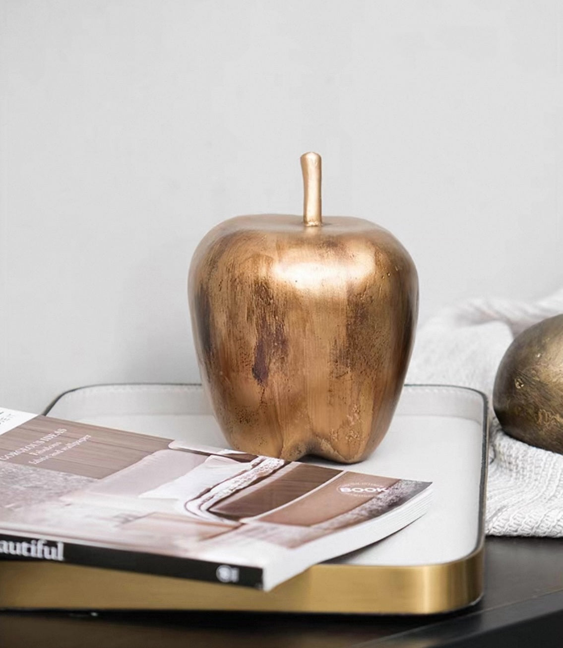 Bronze apple-shaped object on a magazine with a white background