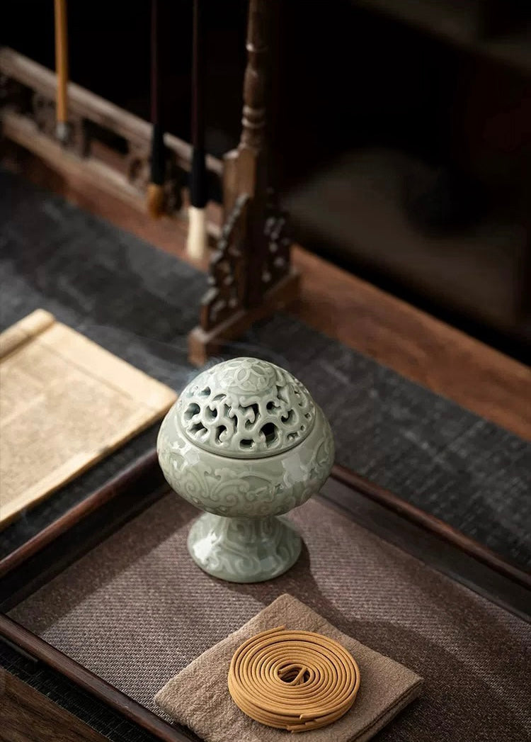 Ceramic incense burner on a textured surface with a blurred background