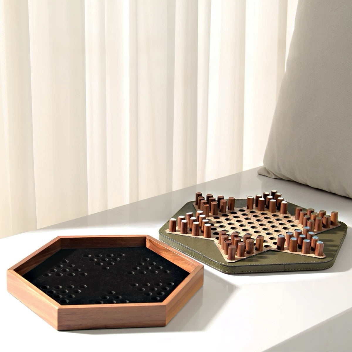 Two wooden board games on a light surface with a neutral background