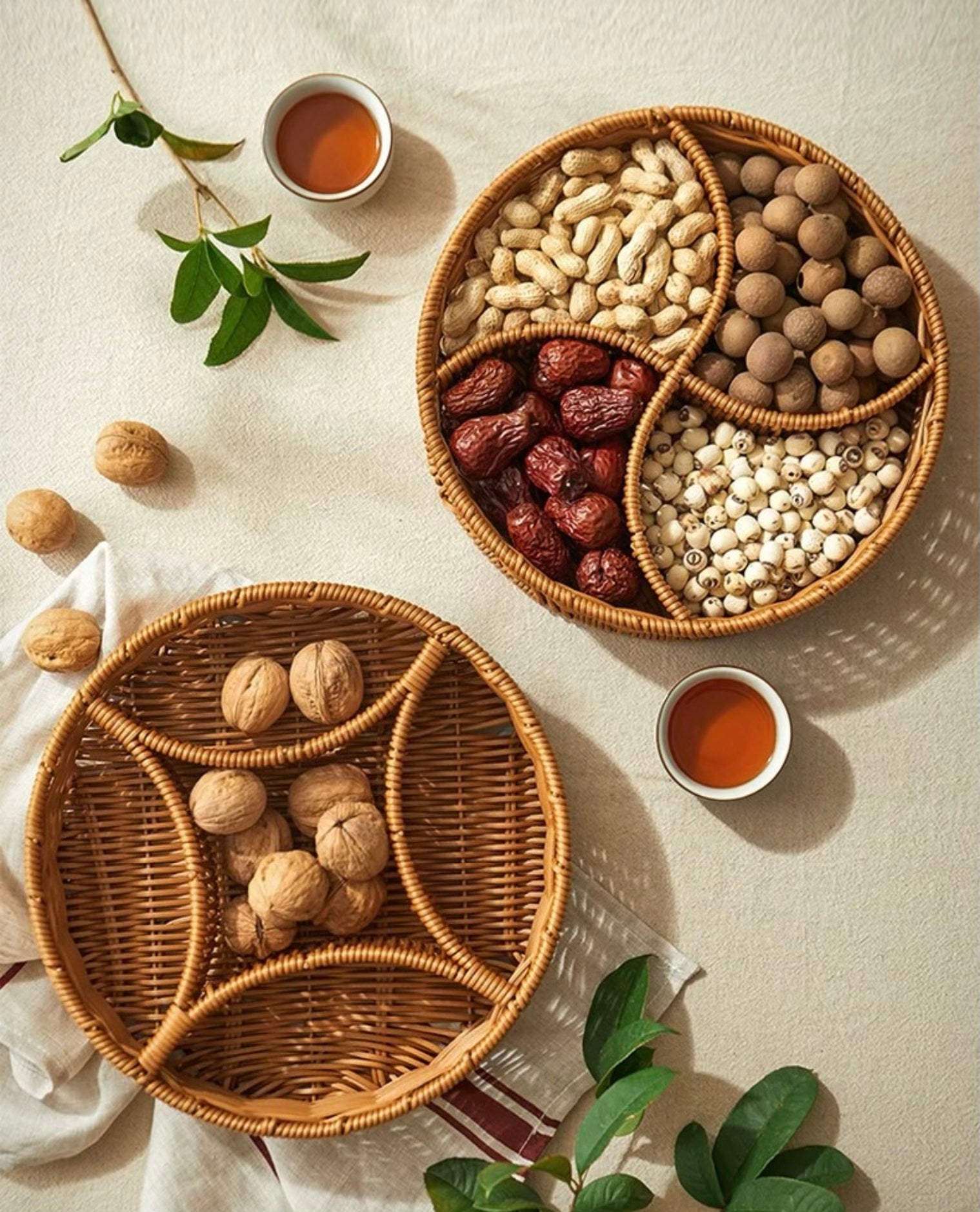 Two woven baskets filled with various nuts and dried fruits on a light surface.