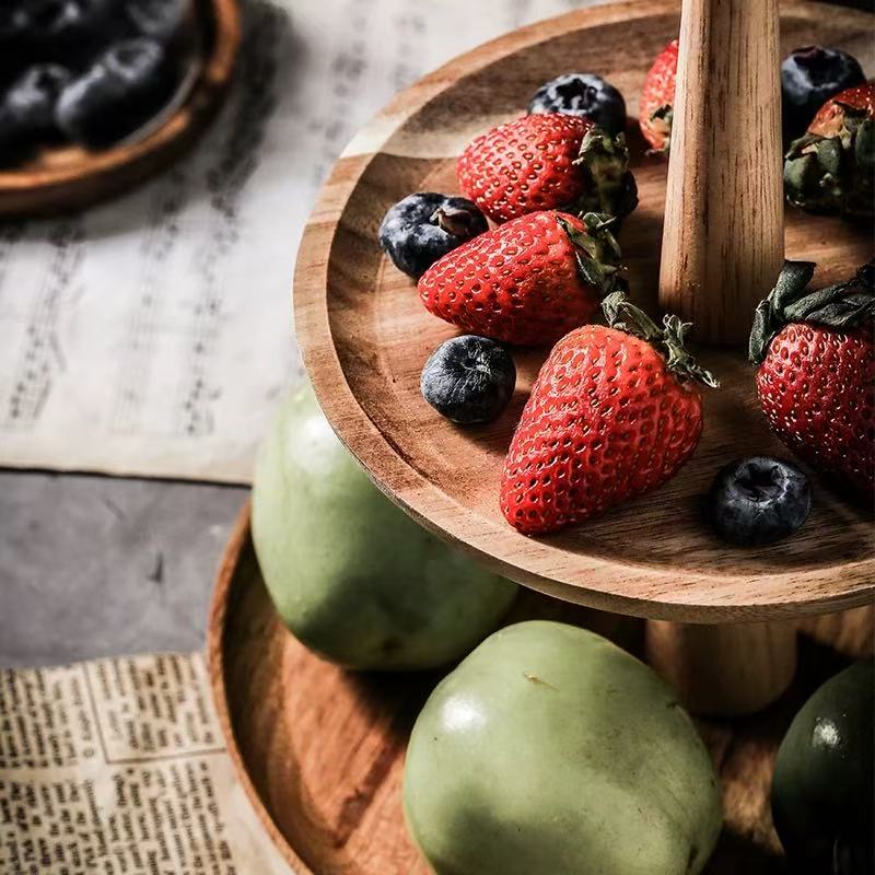 Wooden plate with strawberries and blueberries on a rustic surface