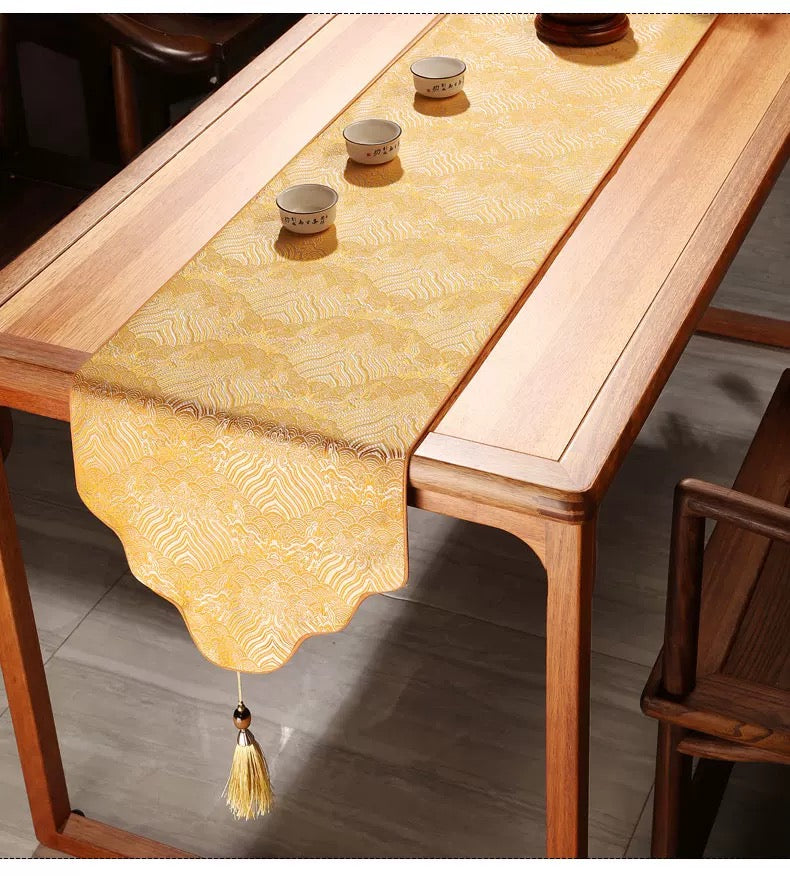 Yellow table runner with tassel on a wooden table