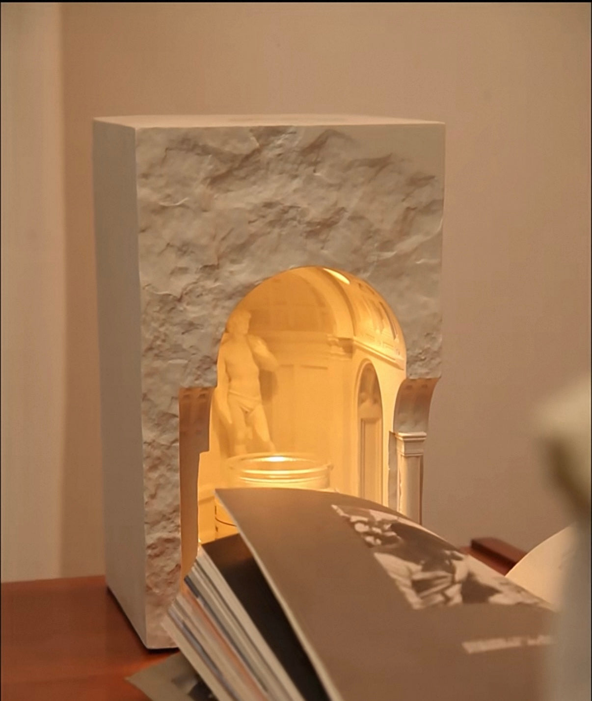 Decorative lamp with marble base and gold interior on a table.