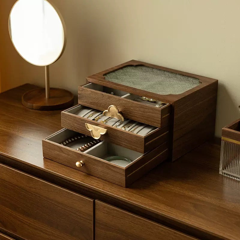 Wooden jewelry box with drawers on a wooden surface