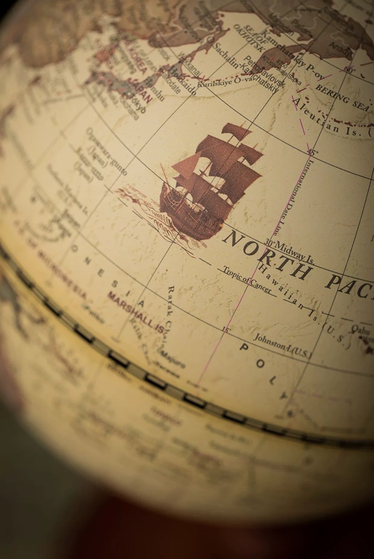 Close-up of a vintage-style globe focusing on the North Pacific region.