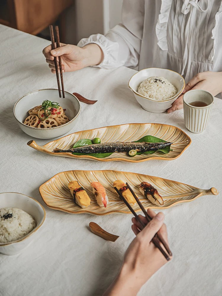 Person eating a meal with chopsticks at a table with various dishes.