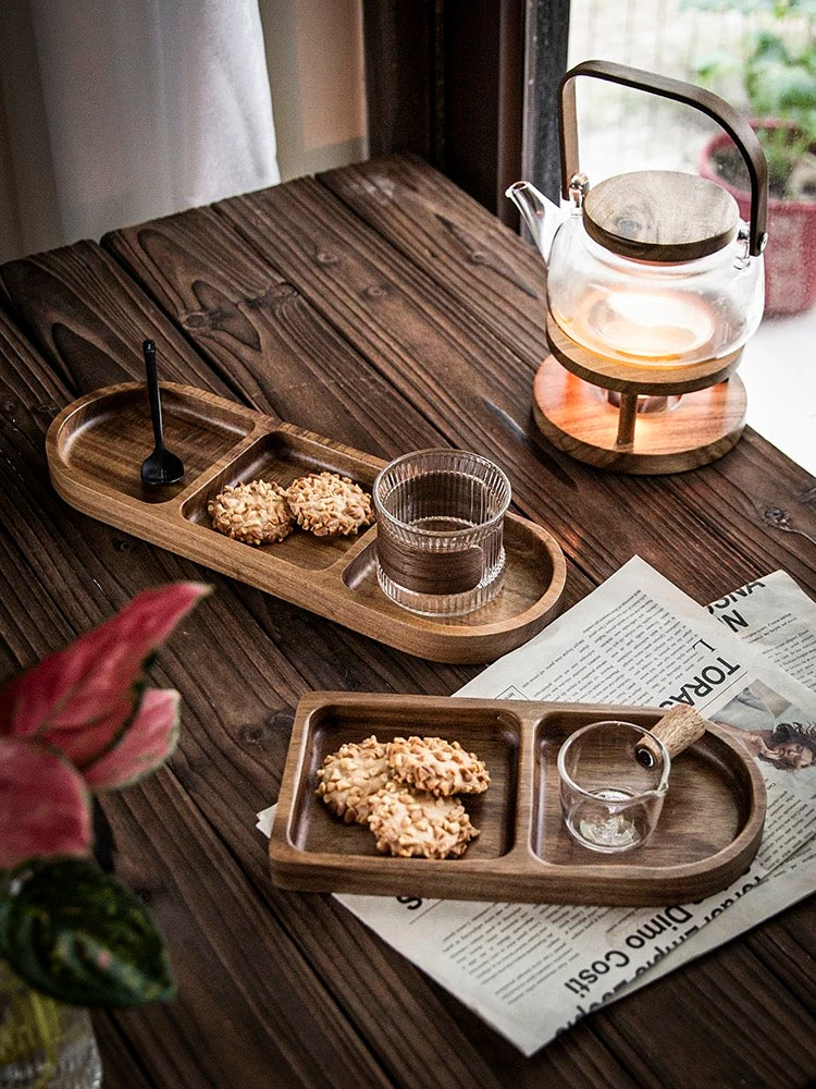 Wooden trays with cookies and a glass, teapot on a wooden table.