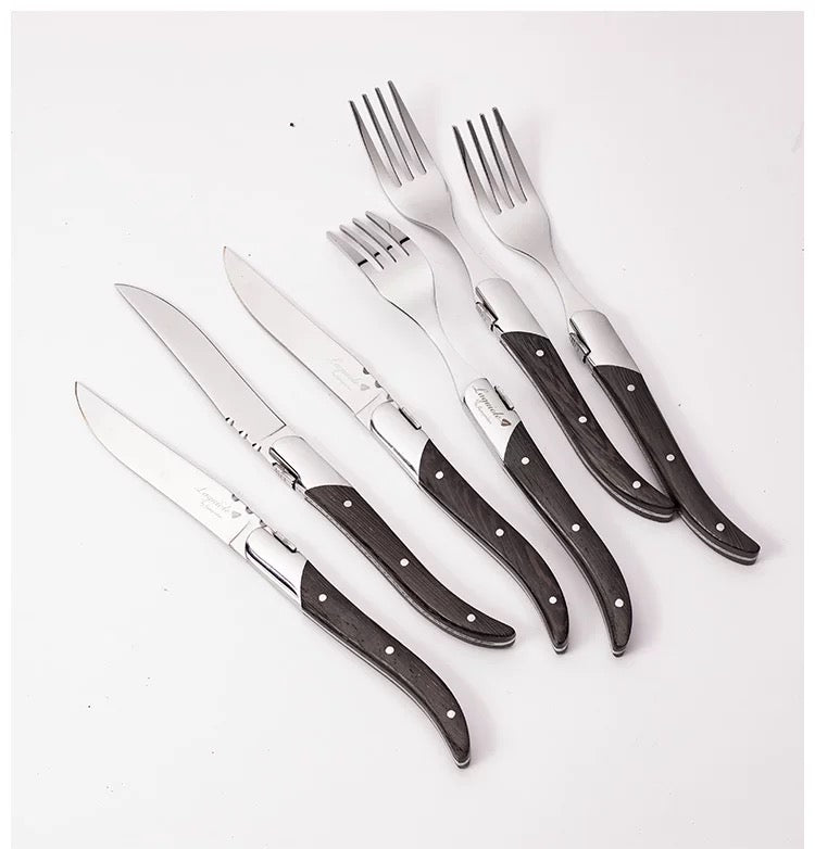 Set of knives and forks with wooden handles on a white background