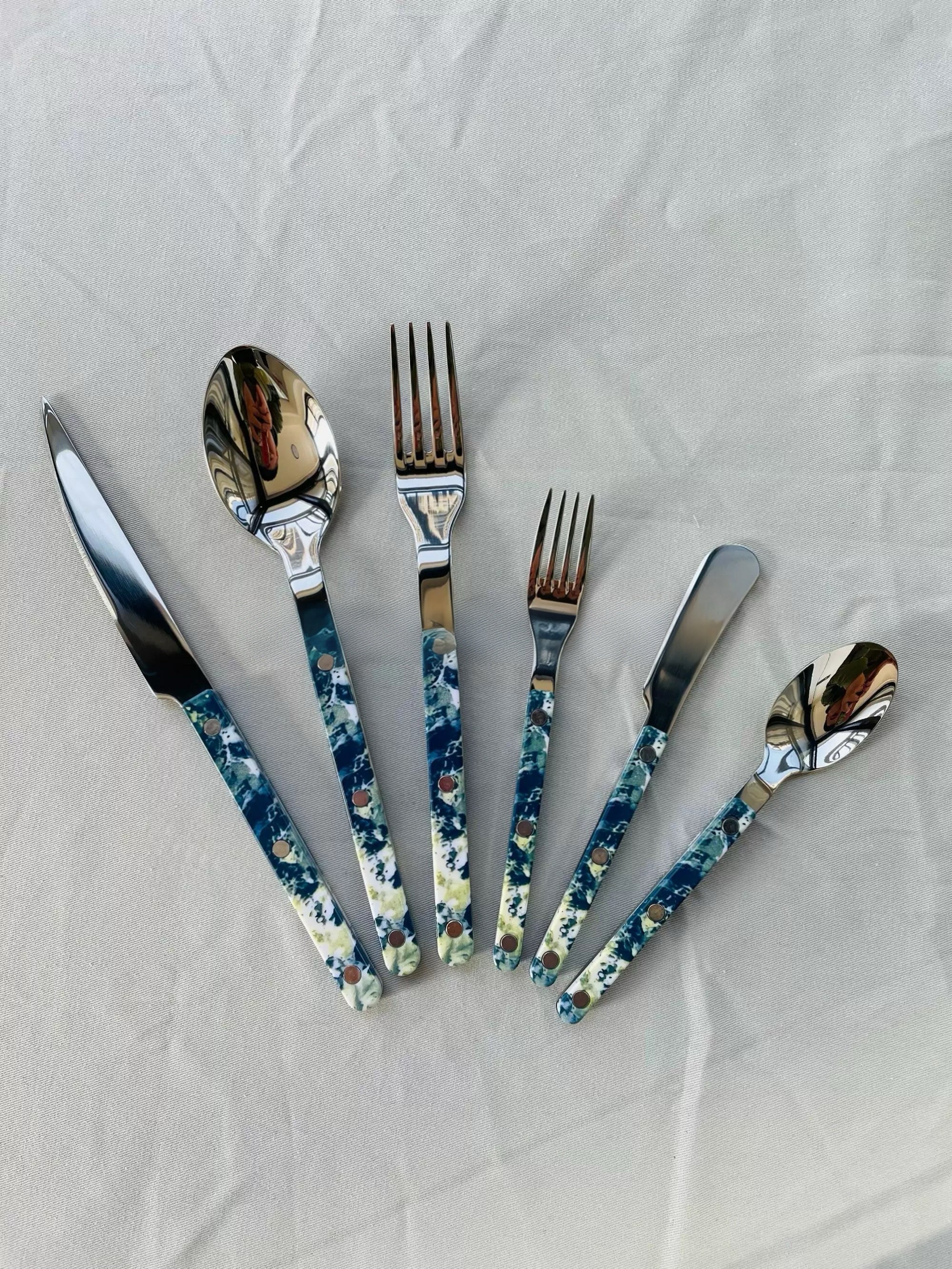 Set of silver cutlery with floral handles on a white background