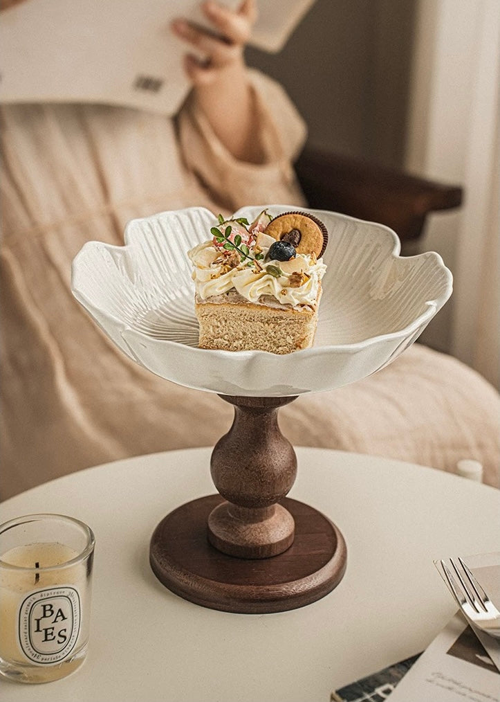 Small cake on a decorative stand with a candle and menu in the background