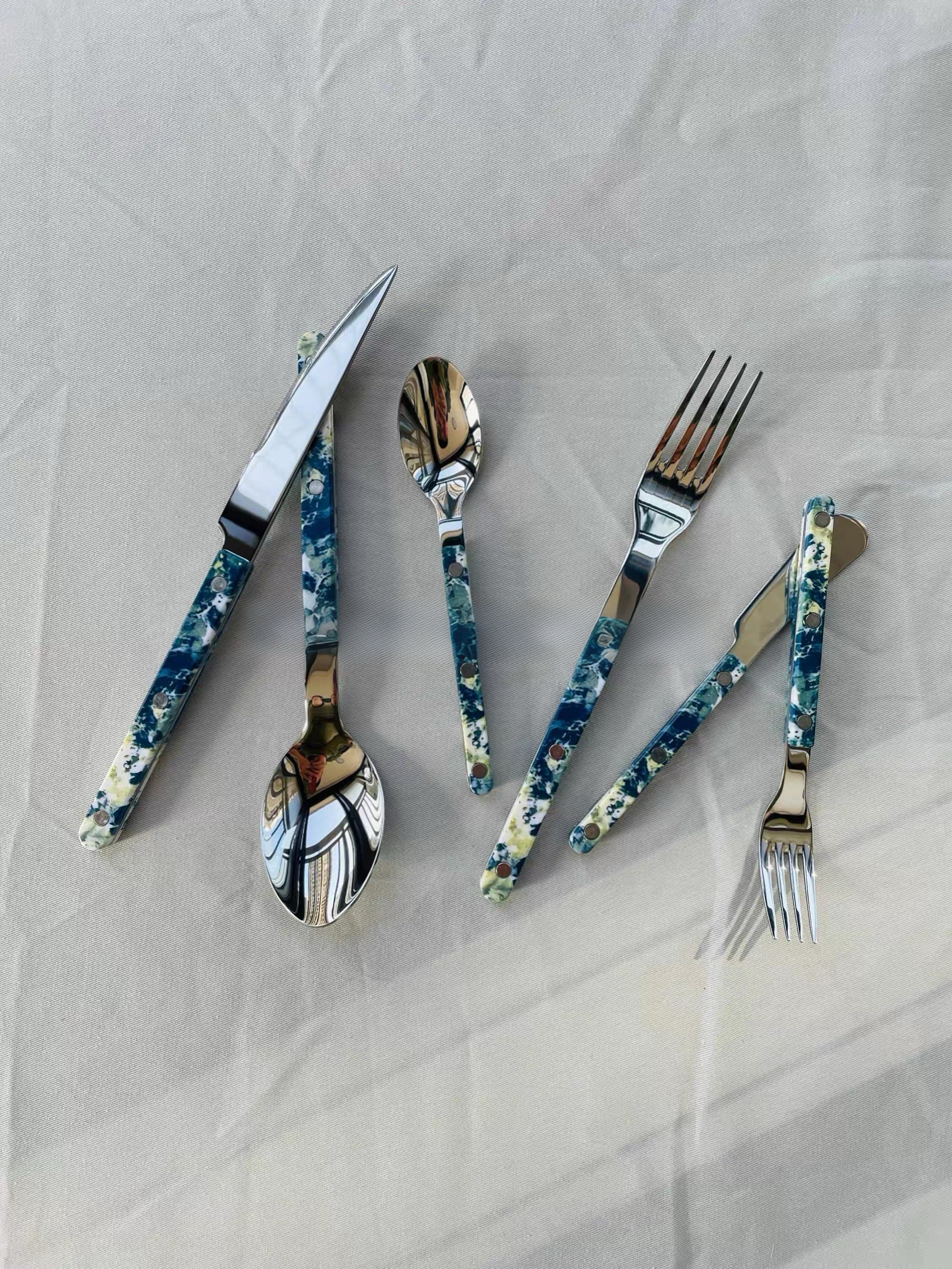 Set of floral-patterned cutlery on a light gray background