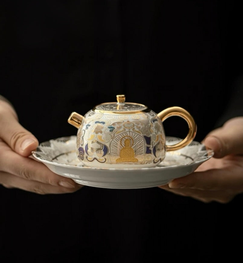 Ceramic teapot with intricate designs held by two hands on a dark background