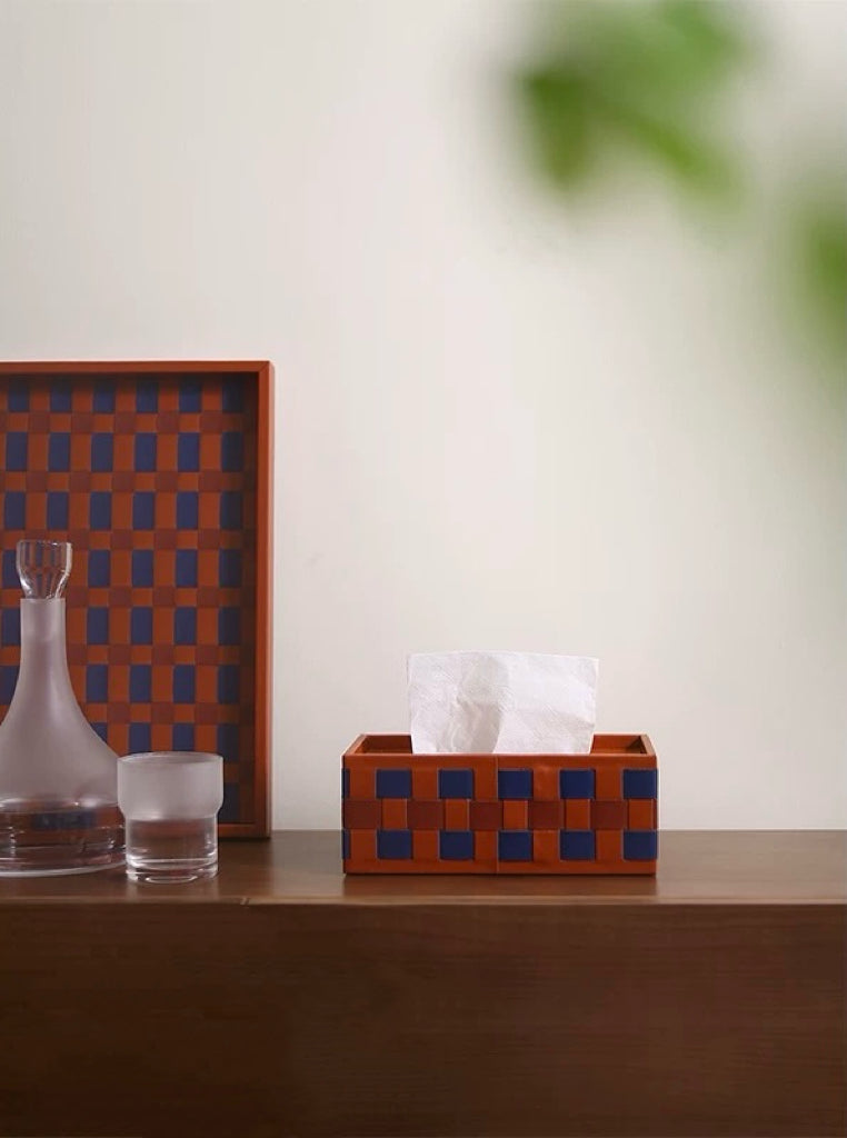 Decorative tissue box with checkered pattern on a wooden surface