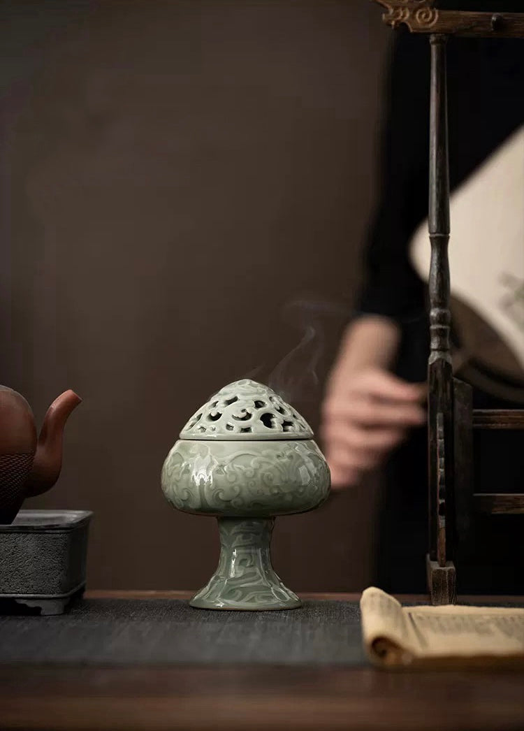 Decorative incense burner on a wooden surface with a blurred background
