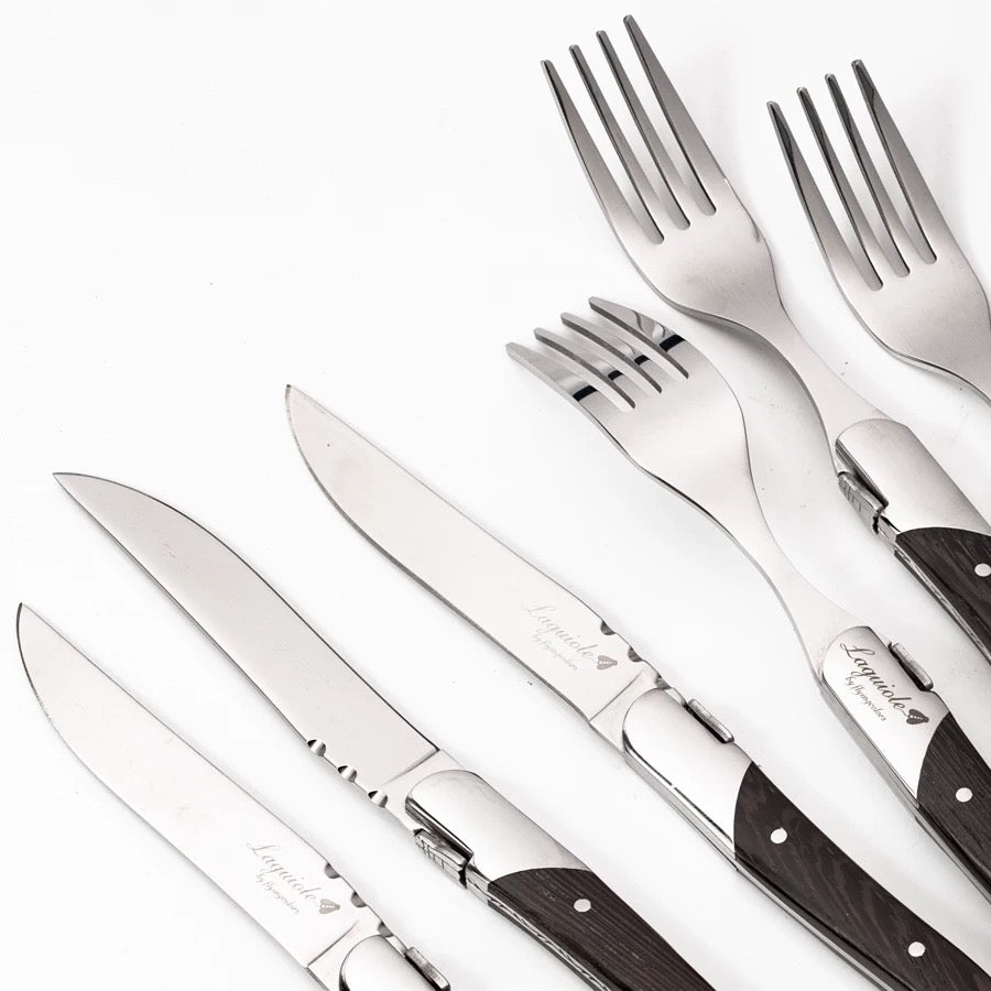 Set of silver cutlery with wooden handles on a white background