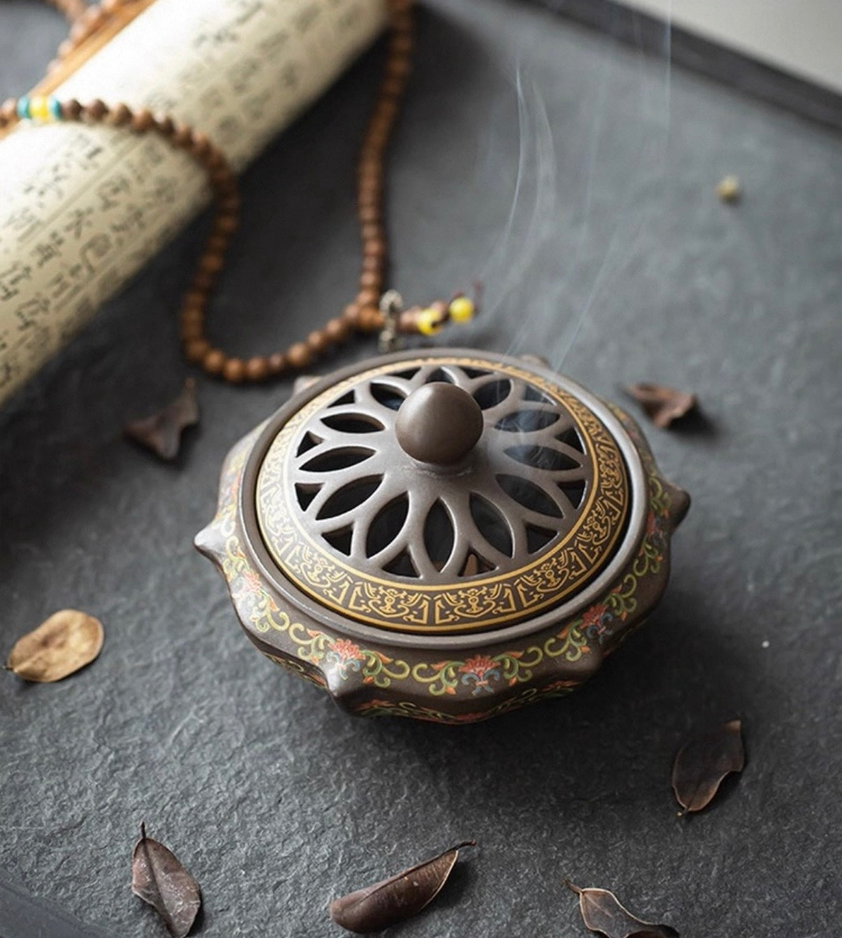 Decorative incense burner with intricate design on a dark surface