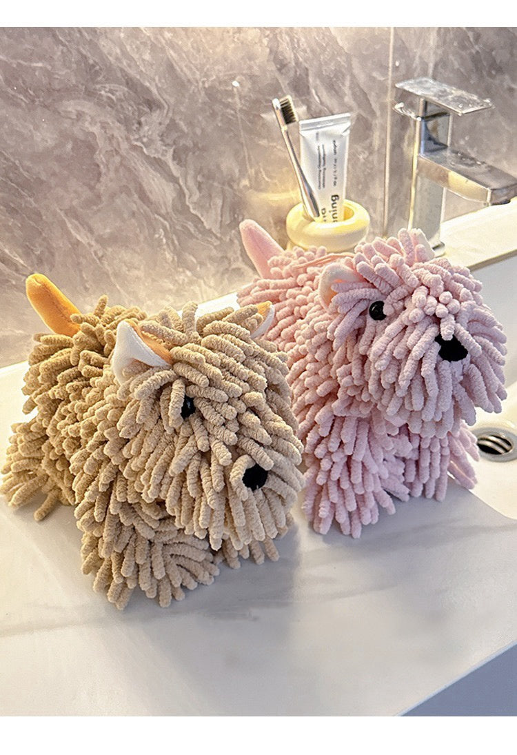 Two plush dog-shaped cleaning sponges, one beige and one pink, on a bathroom counter.