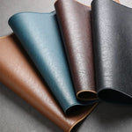 Four leather samples in different colors on a gray background