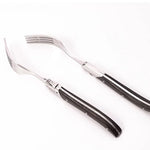 Set of silver cutlery with black handles on a white background