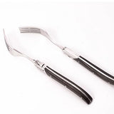 Set of silver cutlery with black handles on a white background