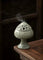 Decorative ceramic incense burner with smoke on a wooden surface
