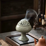 Decorative incense burner with smoke on a wooden table