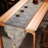 Decorative table runner with tassels on a wooden table