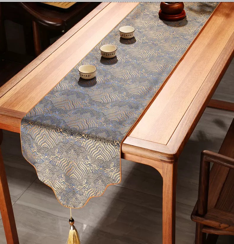 Decorative table runner with tassels on a wooden table