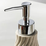 Soap dispenser with a textured beige base and chrome pump on a light background