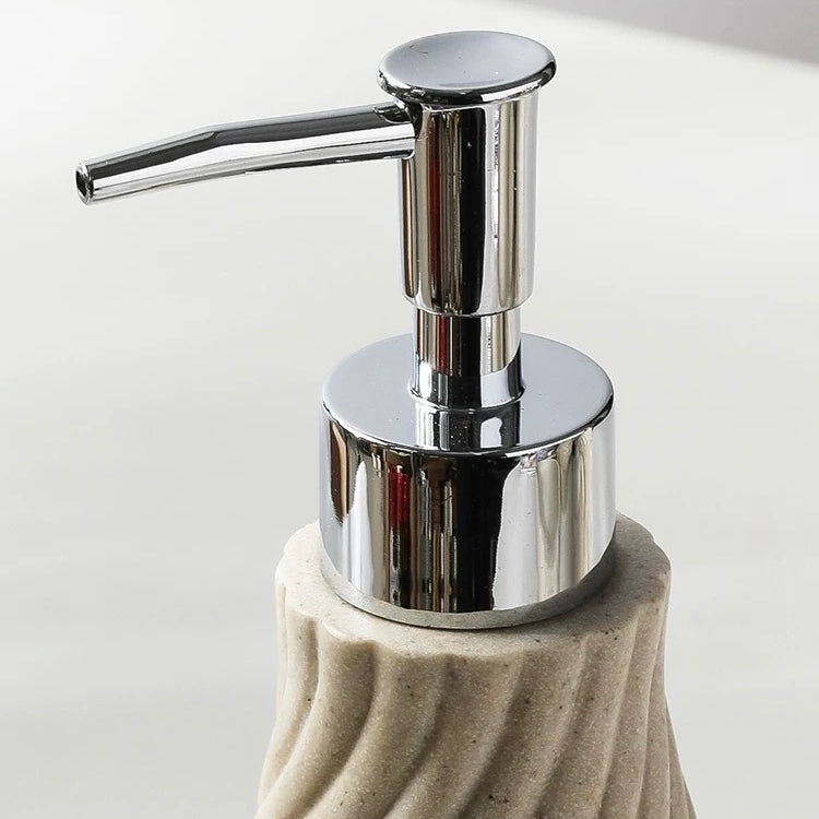 Soap dispenser with a textured beige base and chrome pump on a light background