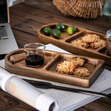 Wooden tray with cookies, a glass of dark liquid, and limes on a wooden table.