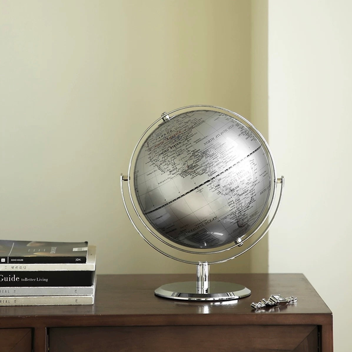 Globe on a wooden surface with books and keys in the background