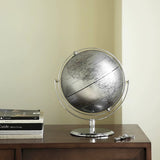 Globe on a wooden surface with books and keys in the background