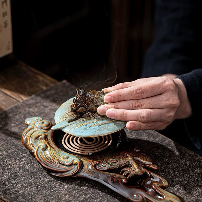 Hand interacting with an ornate metal object on a textured surface